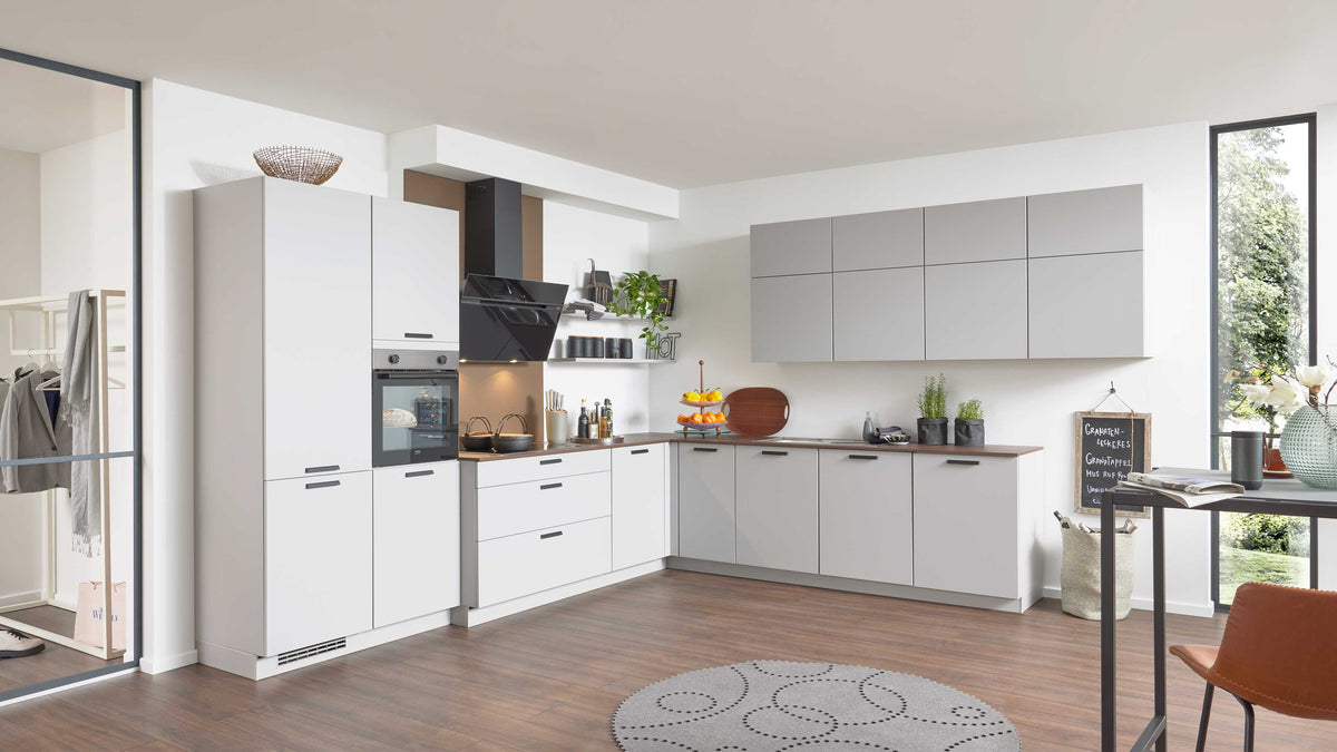 Moderne Küche mit weißen und grauen Schränken, einem schwarzen Kochfeld, einem Holzregal und einem runden Teppich auf Holzboden.