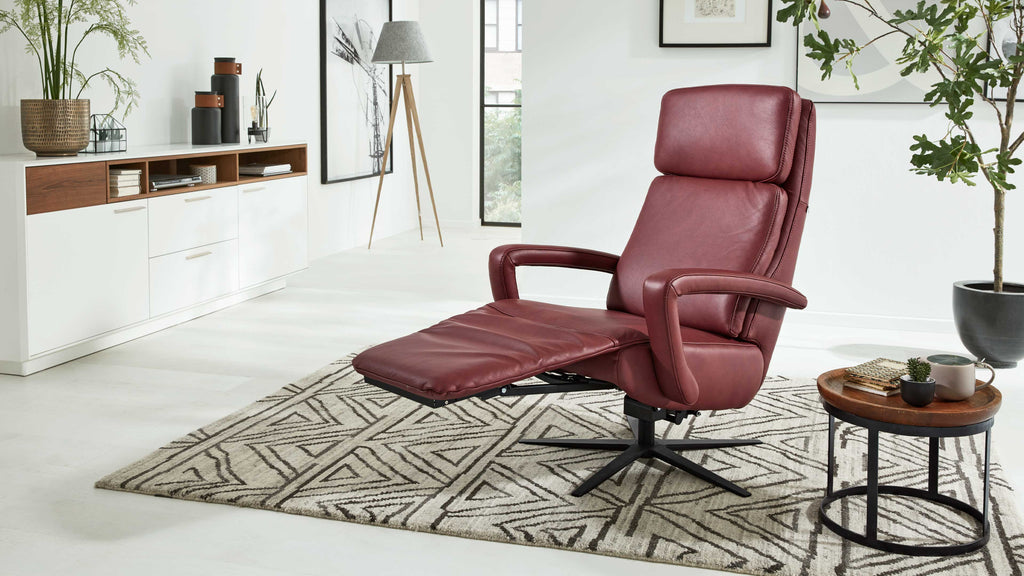 HUKLA® | IL Sessel, Interliving Serie 4541, Leder, Sternfuß auf gemustertem Teppich in einem modernen Wohnzimmer mit Pflanzen.