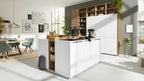 Moderne Küche mit einer großen Kochinsel in Weiß, einem Holzregal im Hintergrund, und einem Essbereich mit grünen Stühlen und einer Holztischplatte.