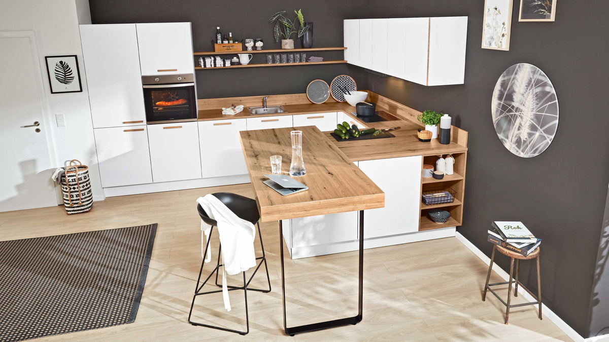 Moderne Küche mit weißen Schränken, Holzarbeitsplatte, integriertem Herd und Dunstabzug, kombiniert mit einem hohen Tisch und Stuhl.