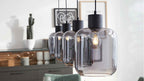 Vier hängende Rauchglas-Pendelleuchten mit schwarzen Fassungen und sichtbaren Filamentbirnen, im Hintergrund Sideboard, Dekor und Kaktus.