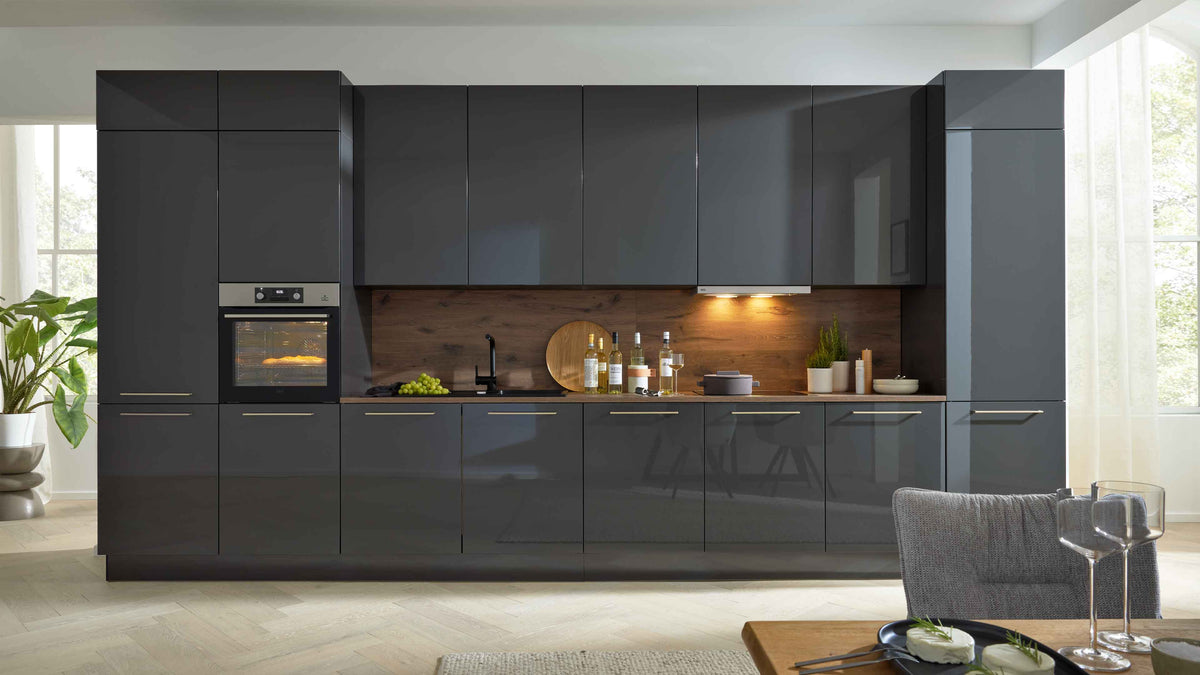 Moderne Küchenzeile in Dunkelgrau mit Holzrückwand, ausgestattet mit einem Ofen, Spüle und dekorierten Ablagen.