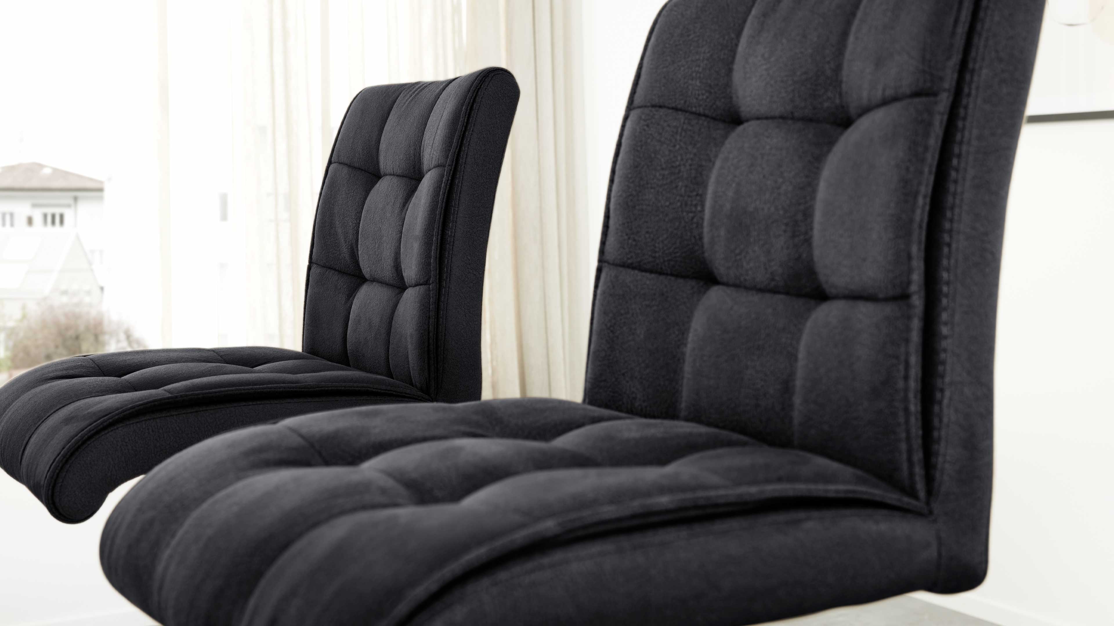 Zwei schwarze, gepolsterte Barhocker, Interliving Serie 5104 von MWA | IL, in Nahaufnahme in einem hellen Raum.