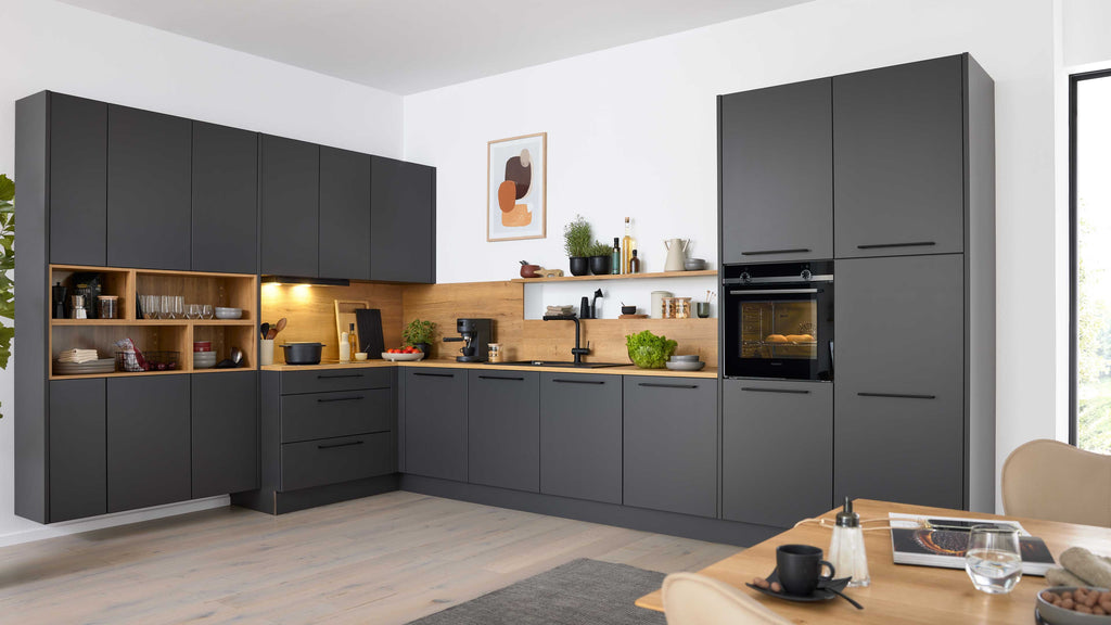 Dunkelgraue L-förmige Küchenzeile mit Holzarbeitsplatte und Holzregalen, eingebautem Ofen, schwarzem Hahn und Kaffeemaschine.