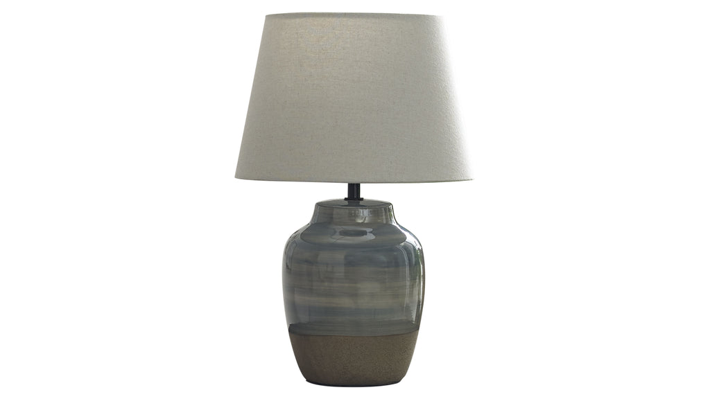 Tischlampe mit beigem Leinen-Schirm und bauchigem Keramikfuß in graublauer Glasur mit rohem, braunem Sockel.