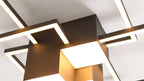 Großformatige geometrische Deckenleuchte mit dunklem Metallkörper, leuchtenden rechteckigen Stäben und quadratischen Paneelen.