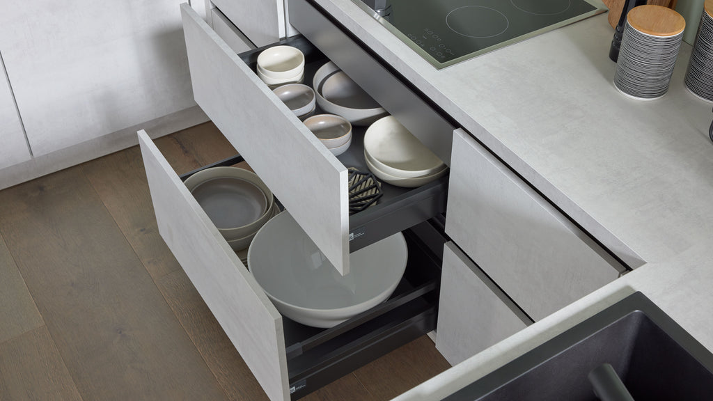 Die offenen Schubladen der Interliving-Küche 3280 bieten Platz für Teller und Schalen in der Farbe „Beton Weiß“ von nolte® KÜCHEN | IL.