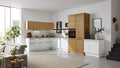 Eine moderne Küche in Weiß und Holz mit Ober- und Unterschränken, einem Kochfeld, Backofen und einer offenen Wohnzone mit Sofa und Teppich.