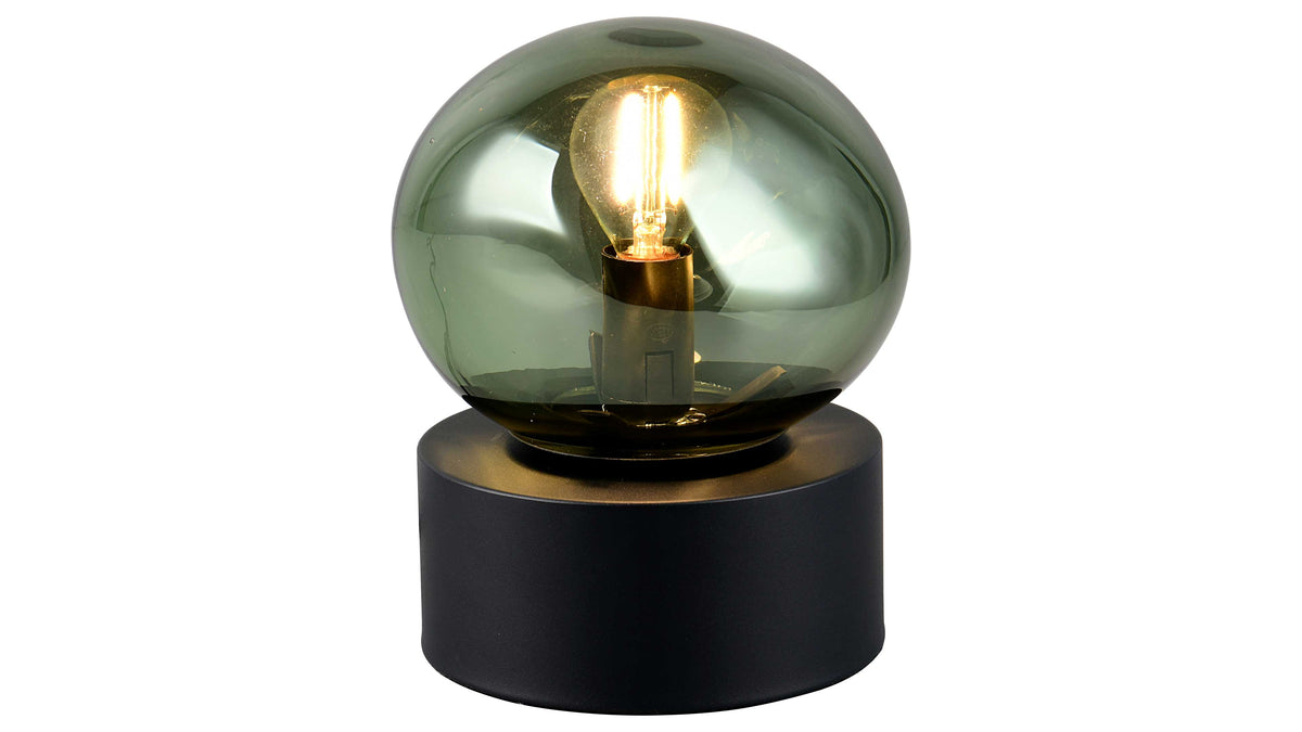 Tischlampe mit grüner, rauchiger Glasglocke und sichtbarer Leuchtfaden-Glühbirne auf rundem, schwarzem Sockel.
