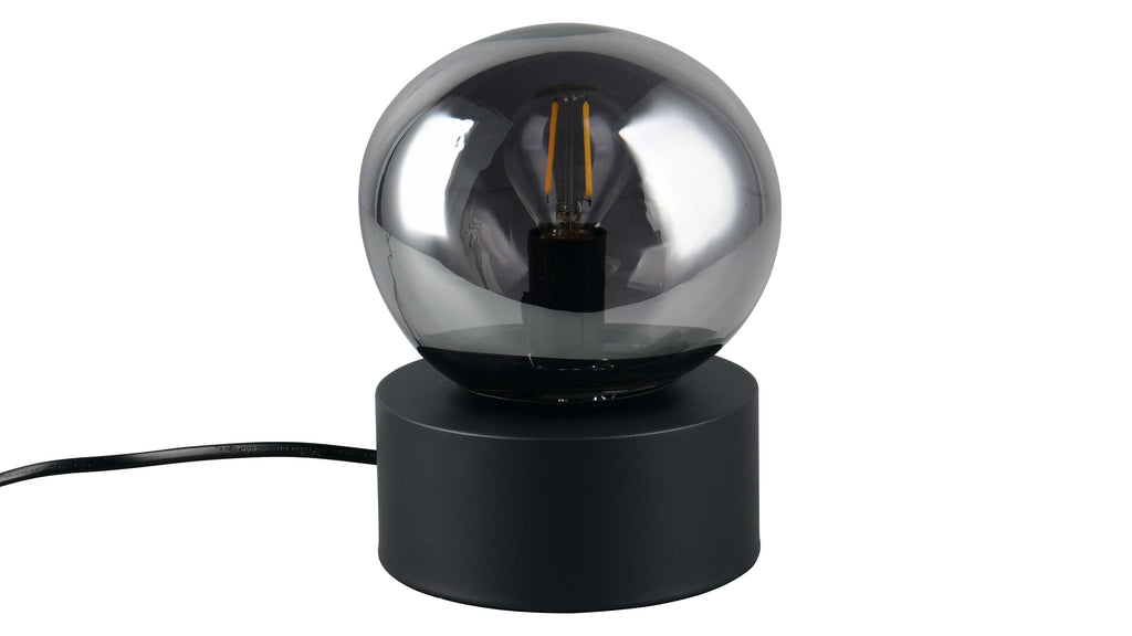 Tischlampe mit rundem, rauchgrauem Glaskugel-Schirm, sichtbarer Filament-Glühbirne und zylindrischem schwarzem Sockel, mit schwarzem Kabel.
