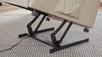 Ein beige gepolsterter Sessel mit einem schwarzen Metallgestell und einem Mechanismus zur Neigungsverstellung steht auf einem hellen, gewebten Teppich.