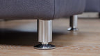 Zwei zylindrische, metallene Modulmaster MM-ZE1049-Sofabeine auf einem Holzboden.