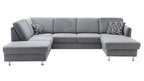 U-förmige, graue Couch mit zwei Kissen in geometrischem Muster und eleganten Metallbeinen.