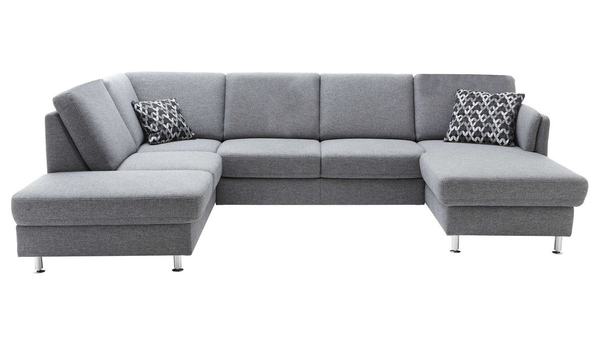 U-förmige, graue Couch mit zwei Kissen in geometrischem Muster und eleganten Metallbeinen.