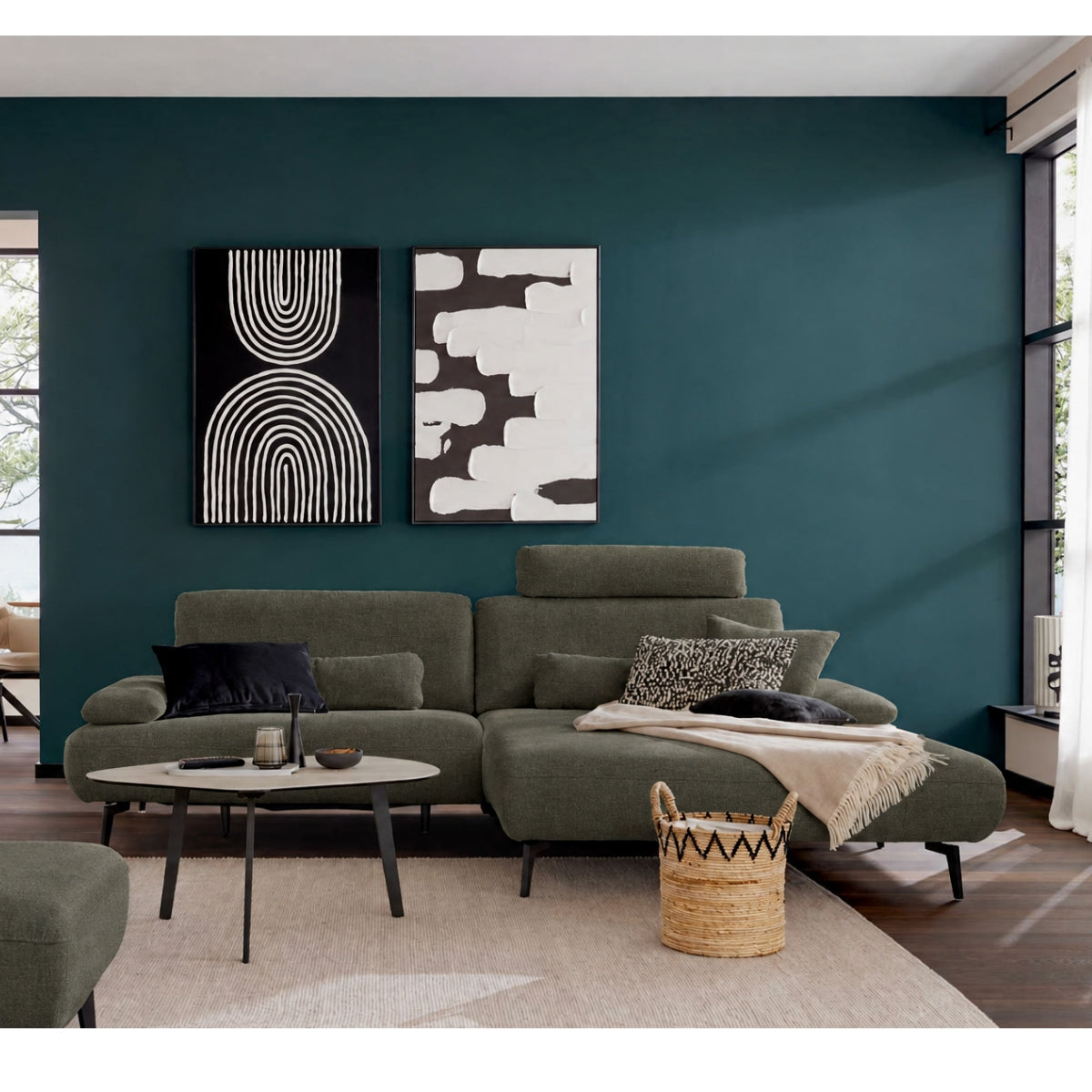 Modernes Wohnzimmer mit ZEHDENICK | IL Interliving Sofa Serie 4306 Jubiläums-Edition, rundem Tisch und Wandbild in Blaugrün.