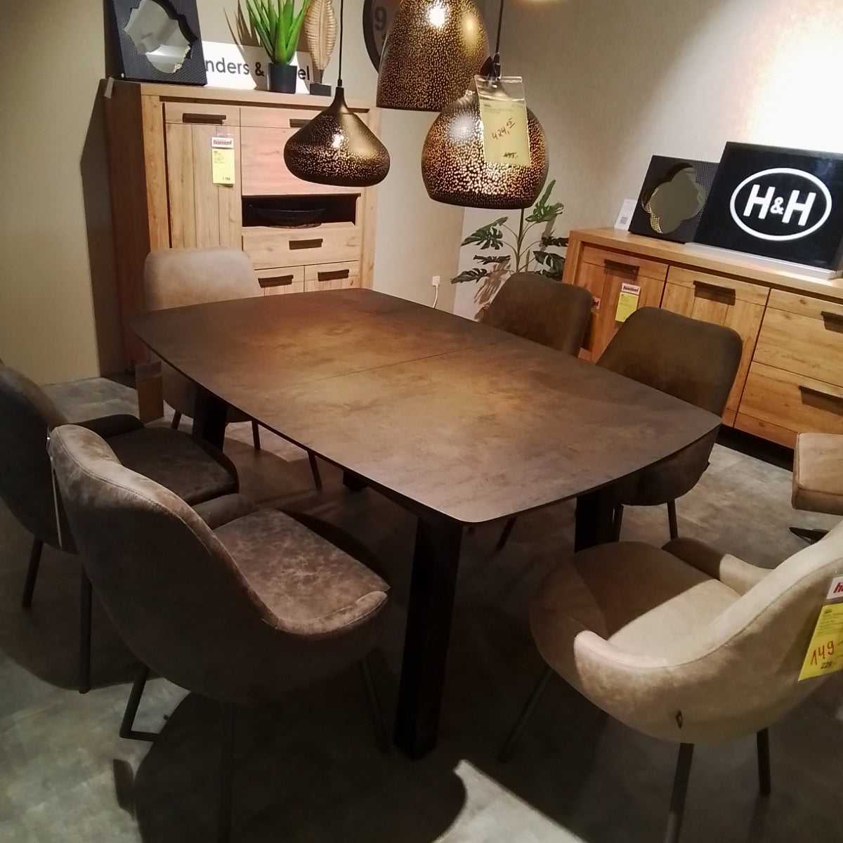 Ein modernes Esszimmer mit einem „0176 Habufa Tisch Palace“, sechs Stühlen, Holzschränken und drei Deckenlampen.