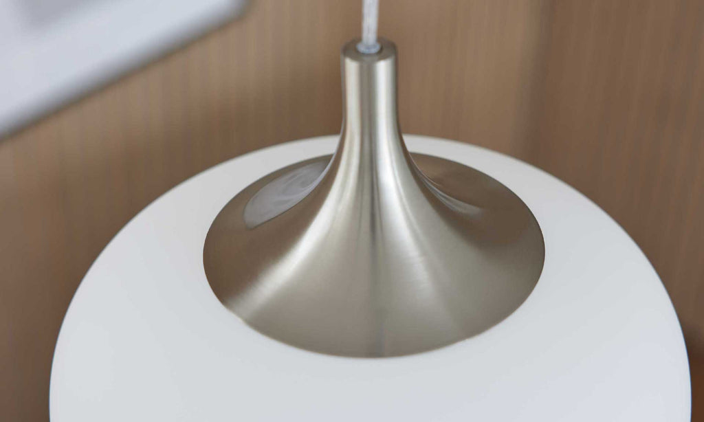 Die obere Ansicht einer modernen Hängeleuchte mit glattem, weißem Schirm und einem schimmernden metallischen Baldachin.