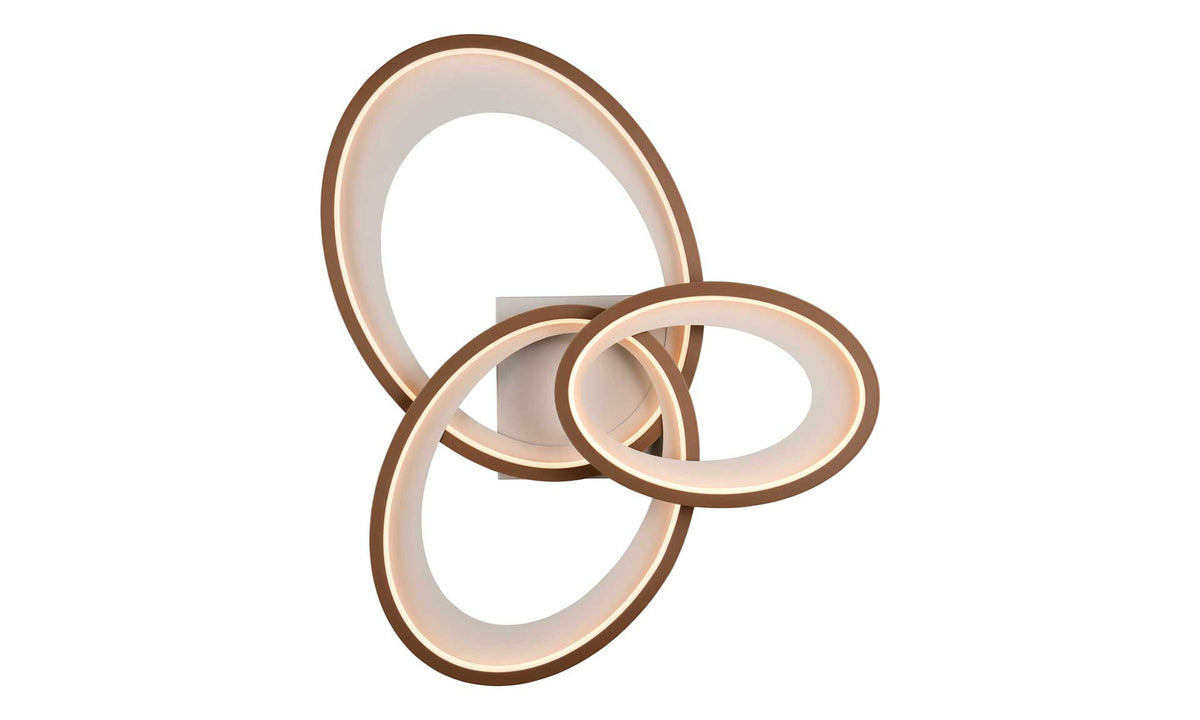 Drei ineinander verwobene, beleuchtete Ringe mit einem braunen Rahmen an einer quadratischen Wandhalterung.