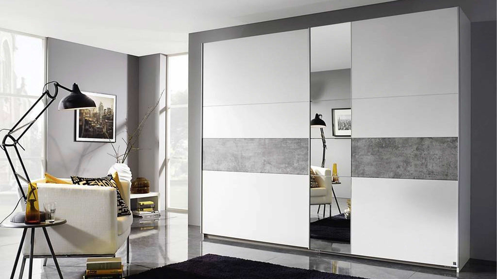 Ein großer, weißer Kleiderschrank mit einem grauen horizontalen Streifen und Spiegeln steht in einem modernen Raum mit einem schwarzen Teppich und einer Lampe.
