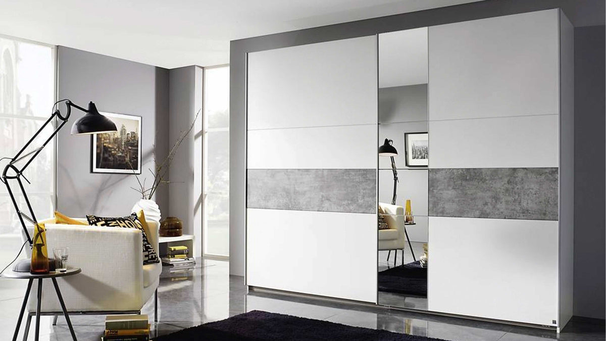Ein großer, weißer Kleiderschrank mit einem grauen horizontalen Streifen und Spiegeln steht in einem modernen Raum mit einem schwarzen Teppich und einer Lampe.