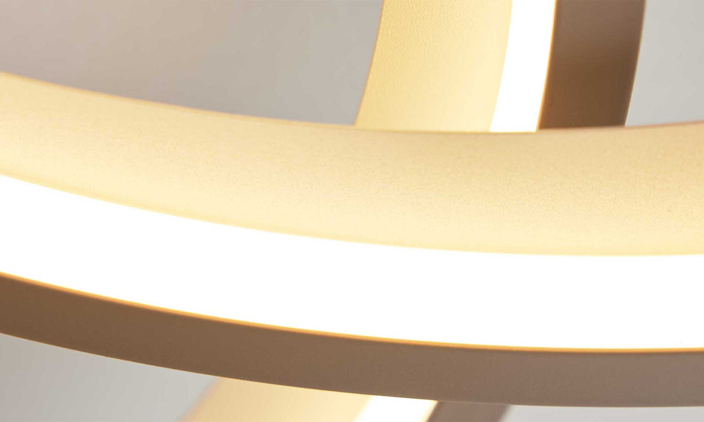 Eine moderne Pendelleuchte mit zwei ringförmigen Elementen in sanften Farben und integriertem, warmweißem Licht.