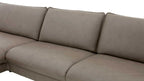 Eine beige, gepolsterte Couch mit zwei hohen Rückenlehnen und einer geteilten Sitzfläche ist sichtbar.
