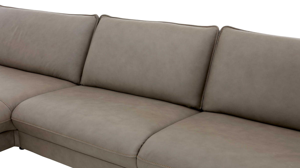 Eine beige, gepolsterte Couch mit zwei hohen Rückenlehnen und einer geteilten Sitzfläche ist sichtbar.