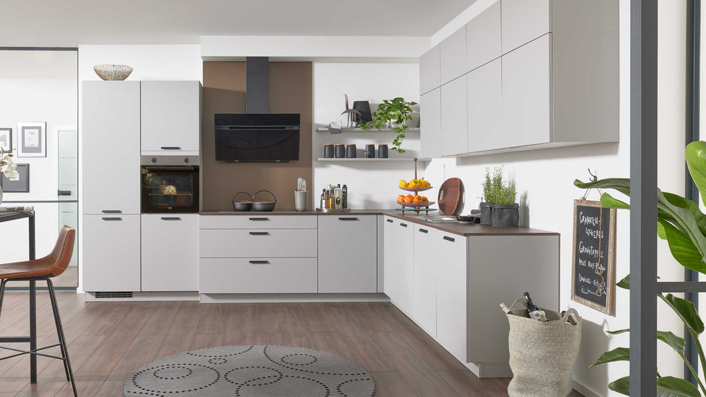 Moderne Küchenzeile in Grau mit Holzarbeitsfläche, ausgestattet mit einem Herd, Backofen, Dunstabzugshaube und Regalen für Küchenaccessoires.