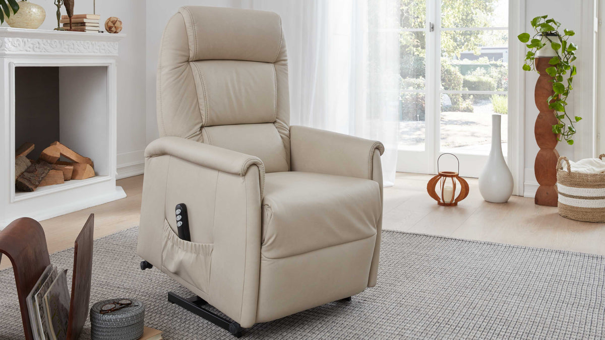 Beige Relaxsessel mit elektrisch verstellbarer Rückenlehne und Armlehnen, platziert auf einem hellen Holzboden in einem gemütlichen Raum mit Fenstern.