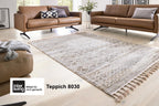 Modernes Wohnzimmer mit zwei braunen Sofas, GOLZE | IL Teppich in Beige/Creme mit Rautenmuster, dekorative Fransen, heller Raum.