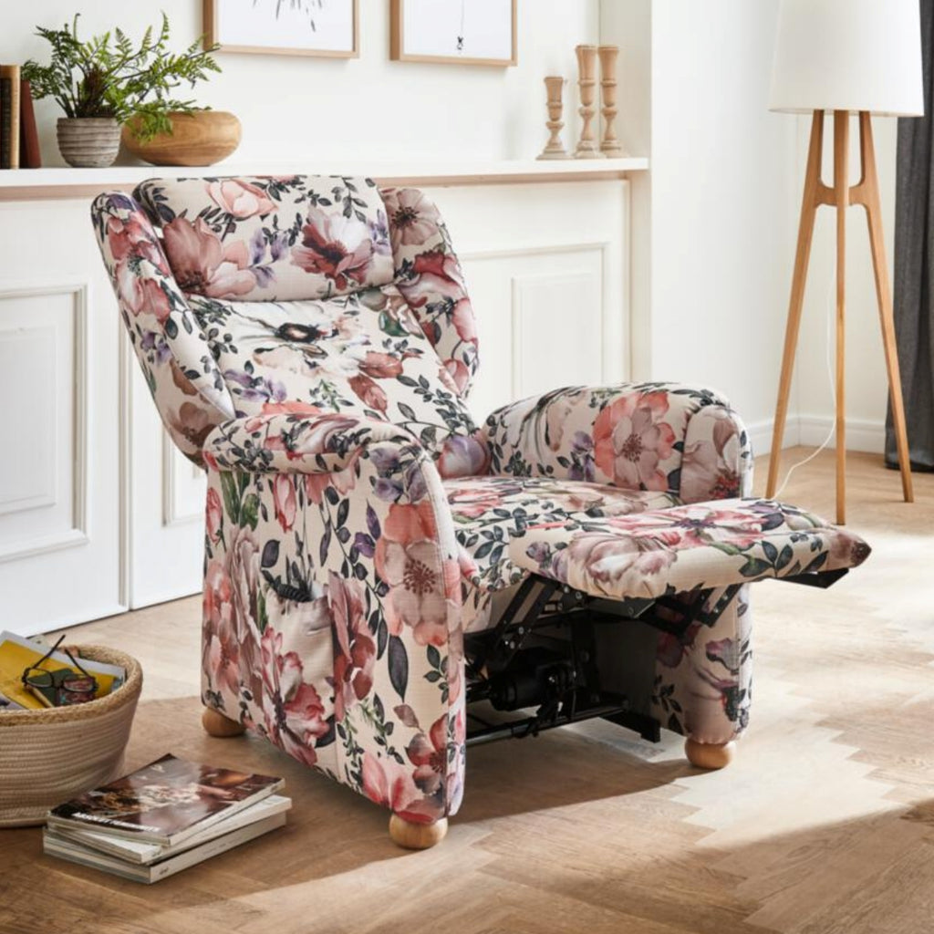 Steinpol Polsteria Ohrensessel mit „Aster Blumen“-Motiv in einem gemütlichen Wohnzimmer mit Holzböden und weißen Wänden.
