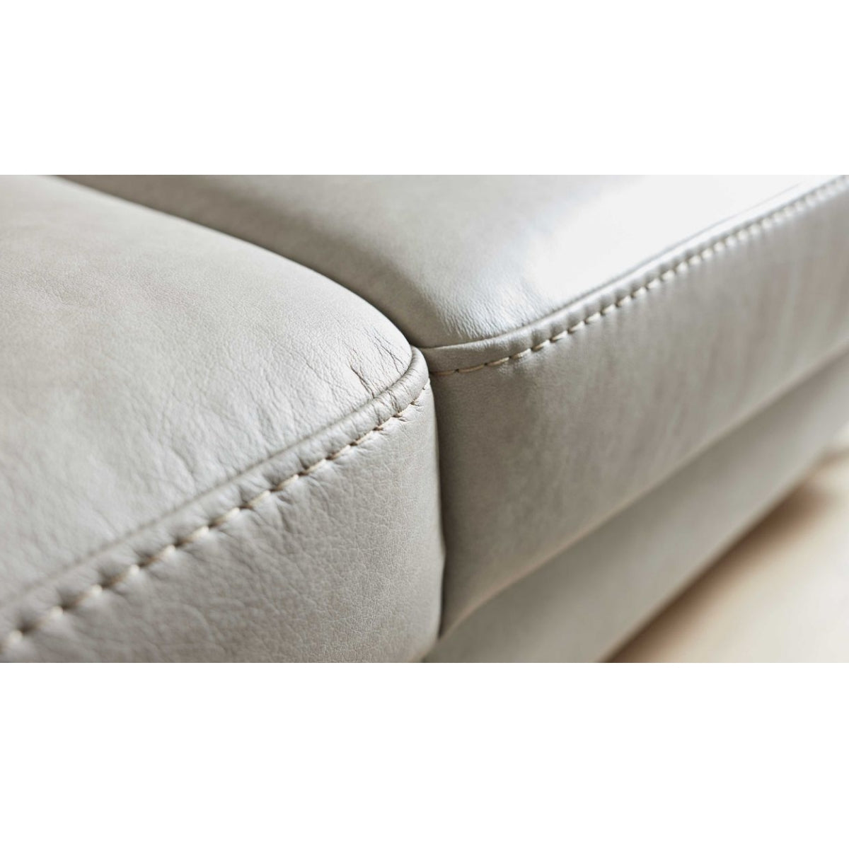Nahaufnahme der Lederkissen in der Farbe „Cloudy Gravel“ mit sichtbaren Nähten am Sofa der Serie 4065 von HUKLA® | IL Interliving.