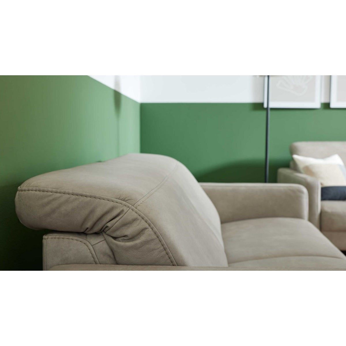 HUKLA® | IL Interliving Serie 4065 2,5-Sitzer aus Leder, Farbe „Cloudy Gravel“, mit Kopfstützen in einem modernen Raum vor einer grünen Wand.