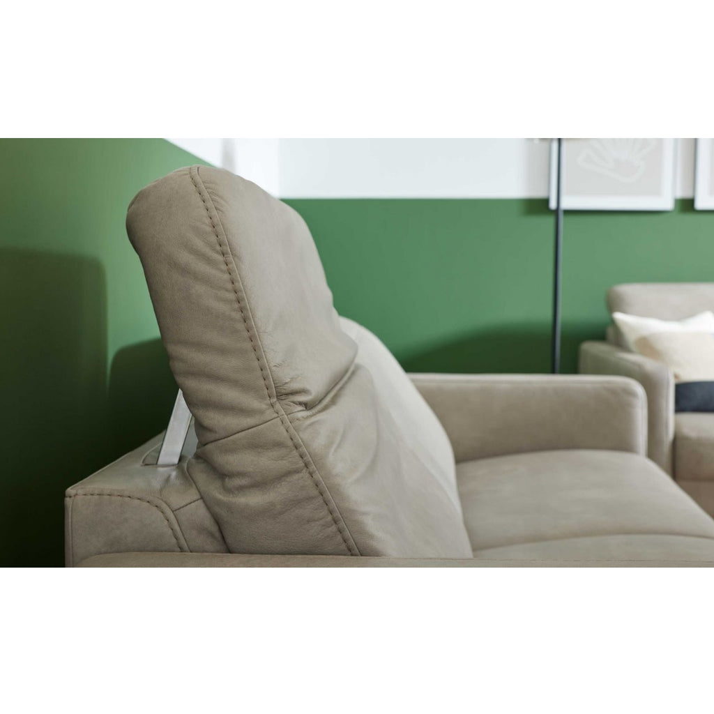 HUKLA® | IL Interliving Serie 4065 2,5-Sitzer in „Cloudy Gravel“-Leder vor einer grün-weißen Wand neben einem Sessel.