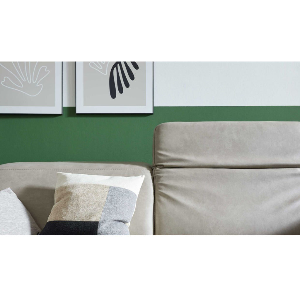 HUKLA® | IL Interliving Serie 4065, 2,5-Sitzer in der Farbe „Cloudy Gravel“ mit Kissen im Color-Blocking-Design, Kunstwerk und grüner Wand.
