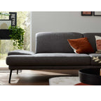 Ein dunkelgraues Zweisitzer-Sofa von Steinpol Polsteria | IL 4460 mit orangefarbenen Kissen belebt das moderne Wohnzimmer.