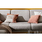 Ecksofa Interliving 4460 in Silber von Steinpol Polsteria | IL mit runden schwarzen Metallfüßen und bunten Kissen.