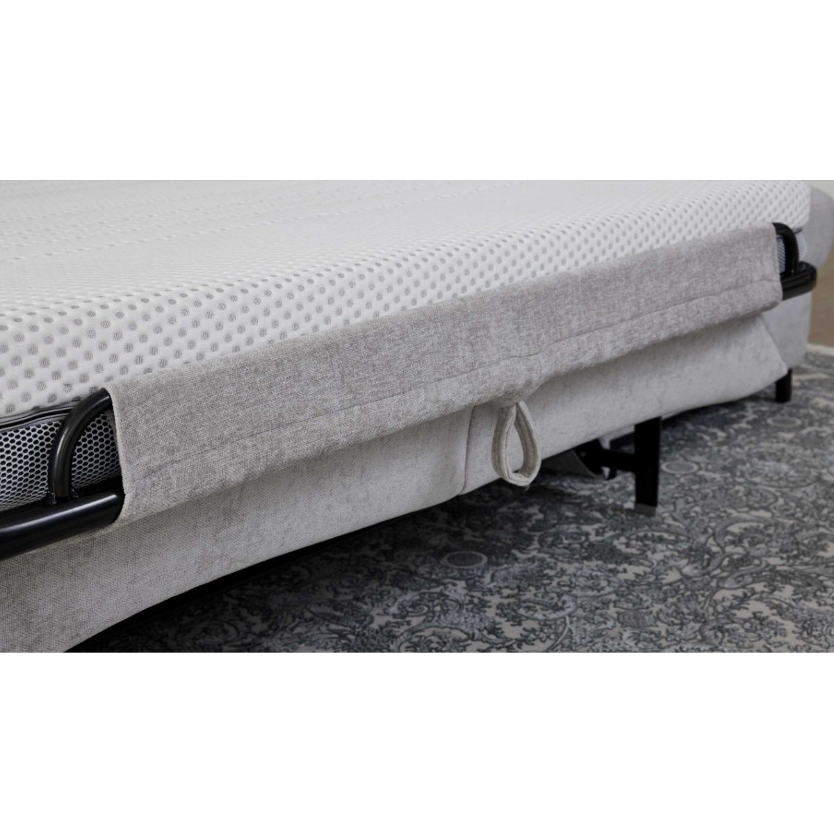 Nahaufnahme einer HUKLA® Interliving 4700 Eckkombination in der Farbe „Toni Silber“ mit schwarzen Füßen und einem gemusterten Teppich darunter.
