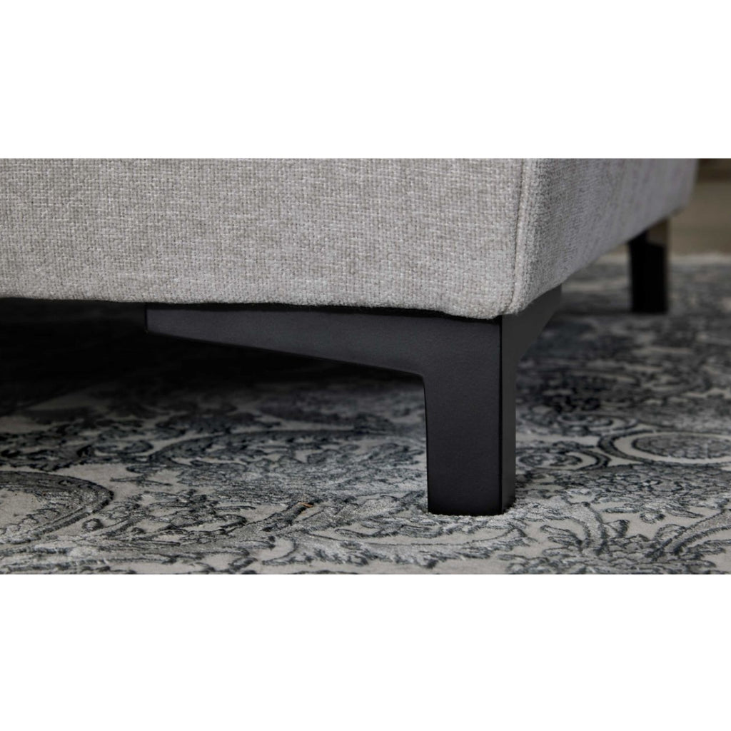 Nahaufnahme der Interliving 4700 Eckkombination in der Farbe „Toni Silver“ von HUKLA® auf einem gemusterten Teppich mit schwarzen Beinen.