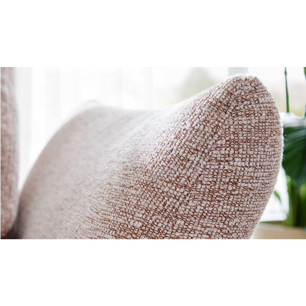 Detailansicht des beigen Kissens „Interliving Serie 4700“ von HUKLA® Comfortbetten, im natürlichen Licht, mit einer verschwommenen Pflanze im Hintergrund.