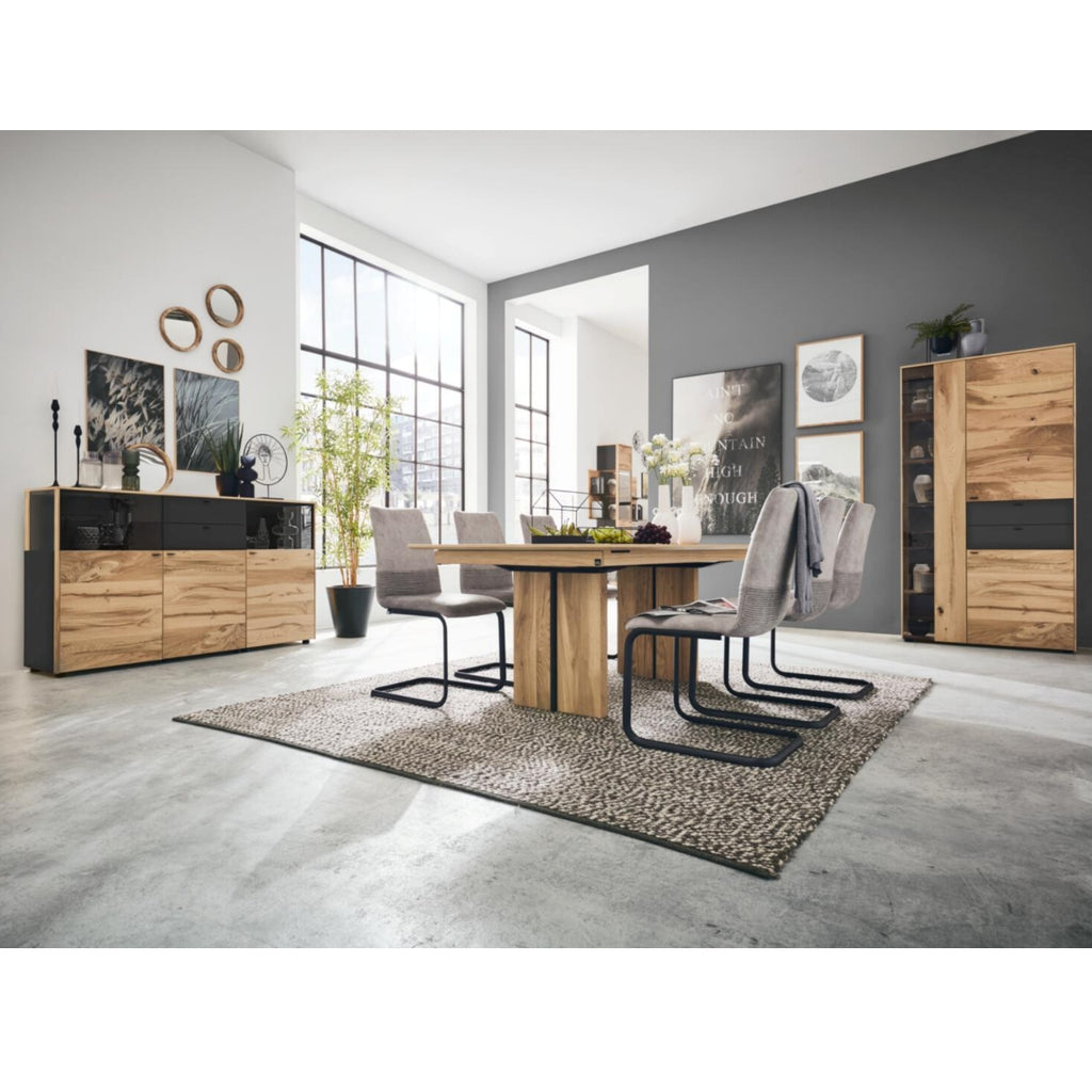 Ein modernes Esszimmer mit Holz, grauen Möbeln, Pflanzen und einem Sideboard der Serie 5604 Eiche von VENJAKOB Interliving.