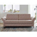 HUKLA® Interliving Serie 4700 Längsschläfer, Loft Siena, abgewinkelte Armlehnen, in Fensternähe auf einem gemusterten Teppich.