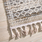 GOLZE | Der Teppich in Beige und Creme mit Rautenmuster und Fransen, abgebildet auf hellem Holzboden verschiedene Größen.