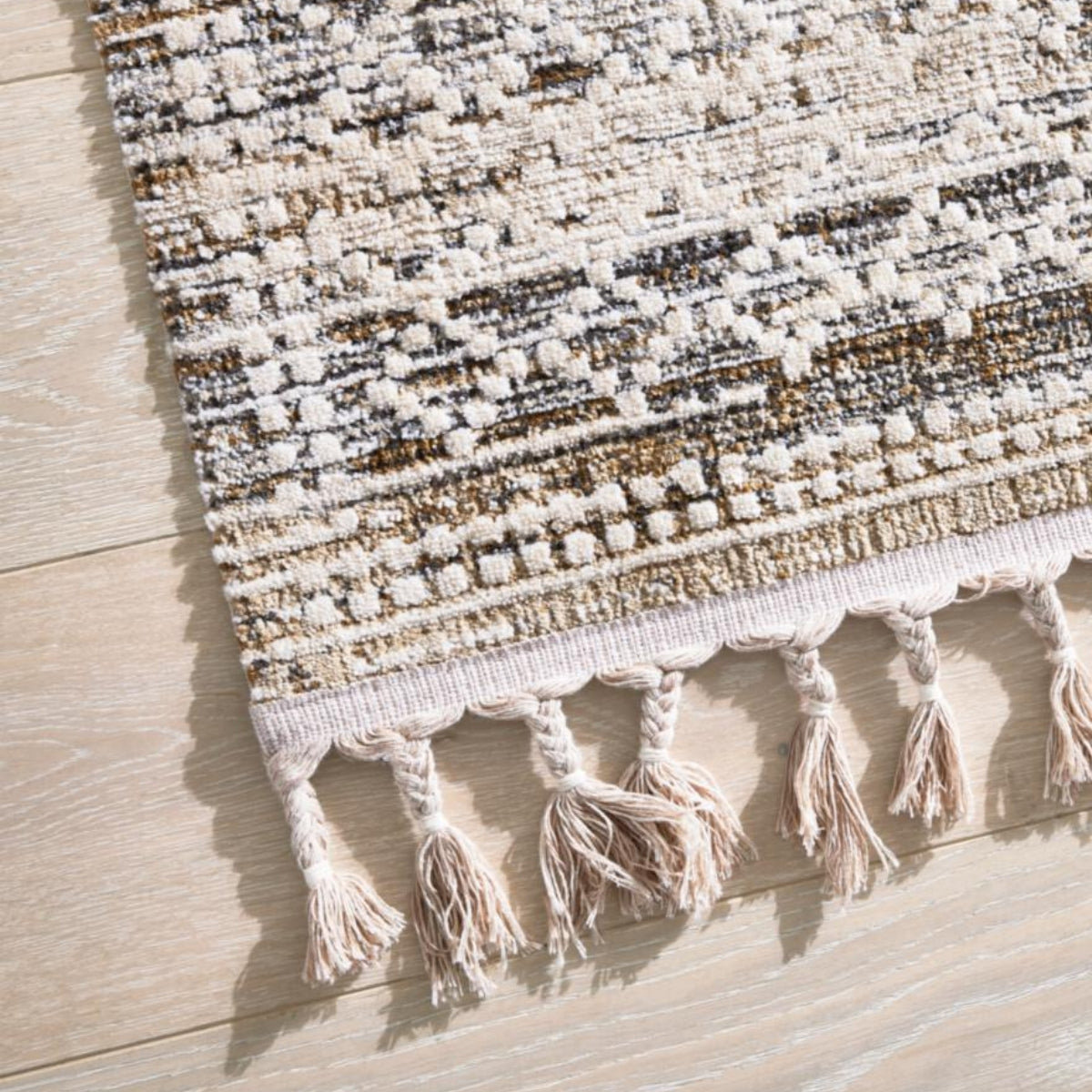 GOLZE | Der Teppich in Beige und Creme mit Rautenmuster und Fransen, abgebildet auf hellem Holzboden verschiedene Größen.