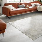 Modernes Wohnzimmer mit Leder-Ecksofa, Kissen in neutralen Farbtönen und einem Teppich von GOLZE | IL Interliving, Modell G-8040, in den Farben Vintage-Beige und Creme.