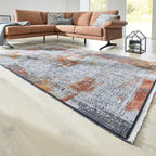 Ein Teppich „GOLZE | IL Interliving G-8060“ in Rost-, Sand- und Grautönen passt in diesem hellen Wohnzimmer perfekt zu einem orangefarbenen Sofa.