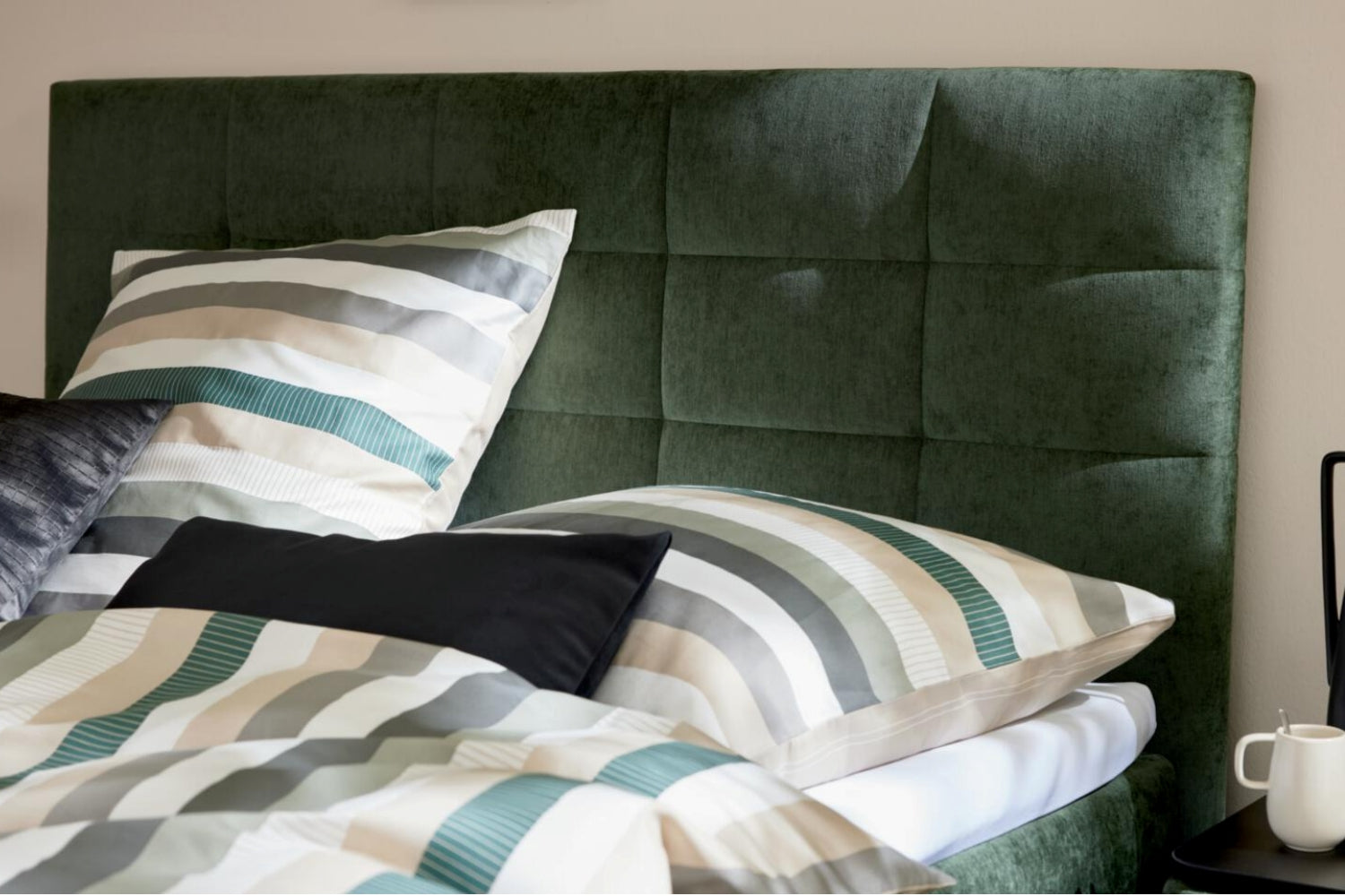 Boxspringbett mit moosgrünem Bezug und schwarzen Metallfüßen