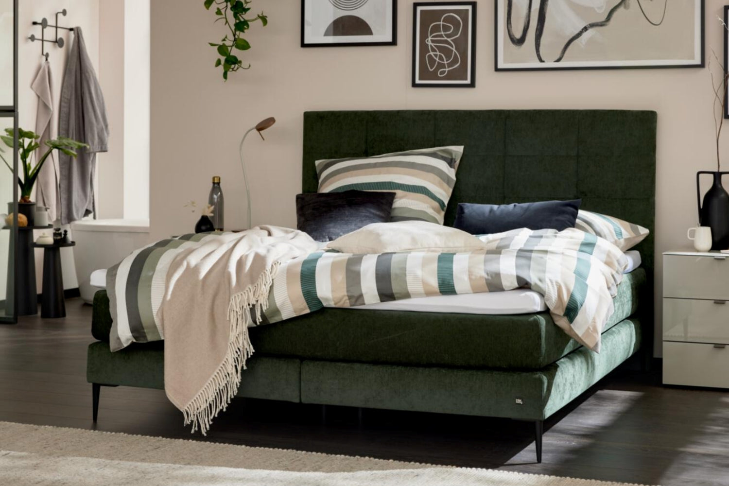 Boxspringbett mit moosgrünem Bezug und schwarzen Metallfüßen