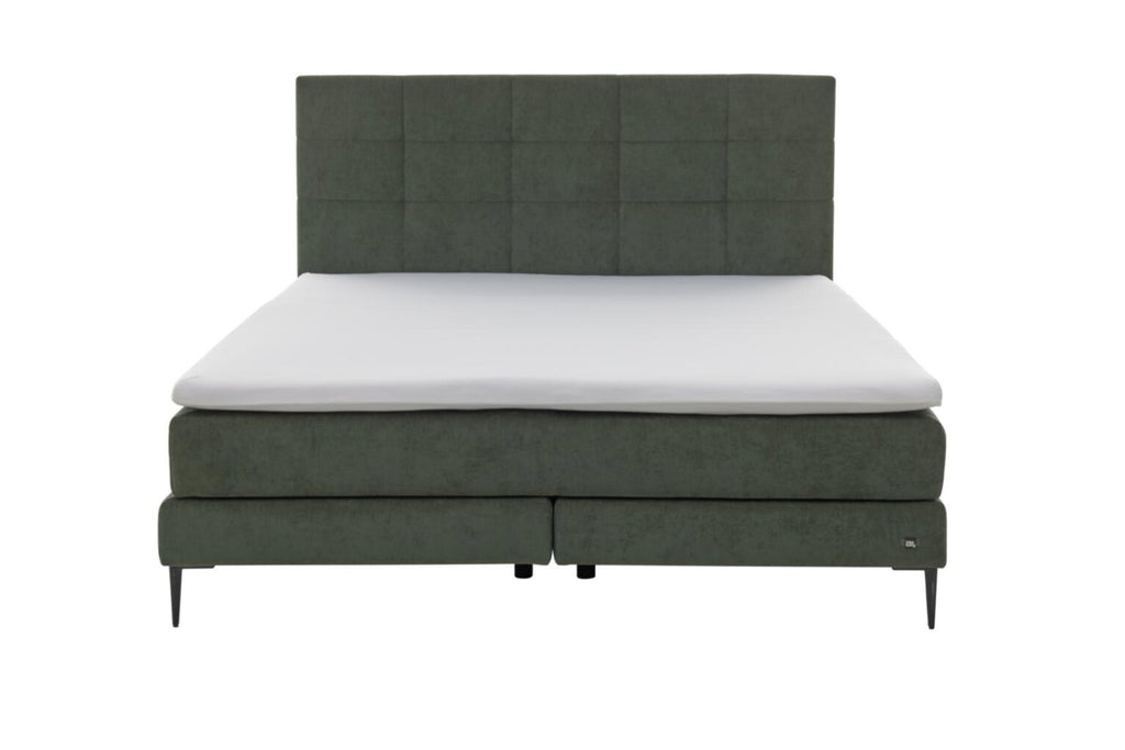 Boxspringbett mit moosgrünem Bezug und schwarzen Metallfüßen