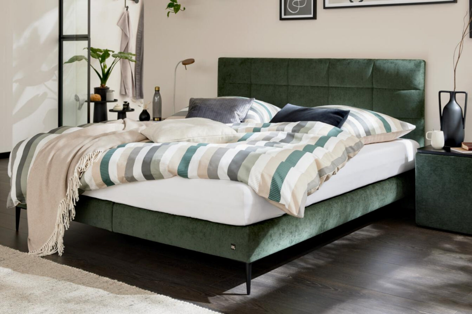 Boxspringbett mit moosgrünem Bezug und schwarzen Metallfüßen